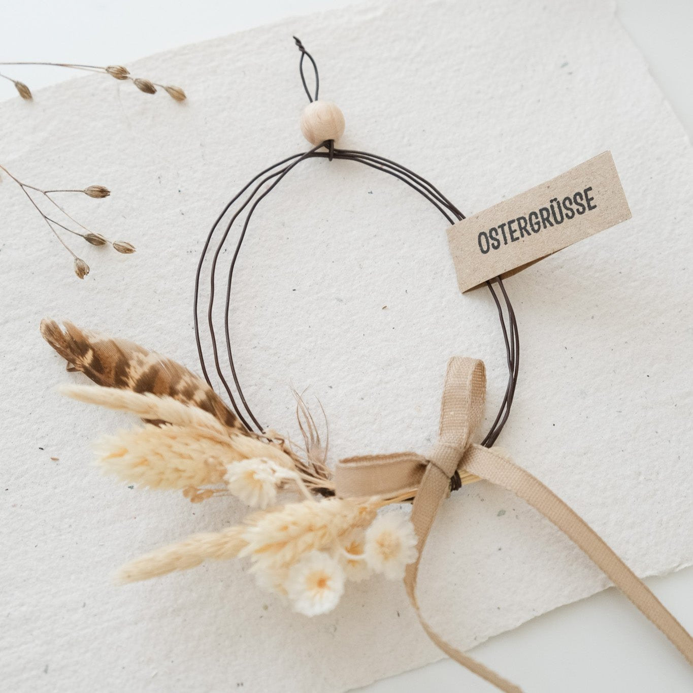Bastelidee für Ostereier Ausstechform. Drahtei mit Trockenblumen und Anhänger "Ostergrüsse".
