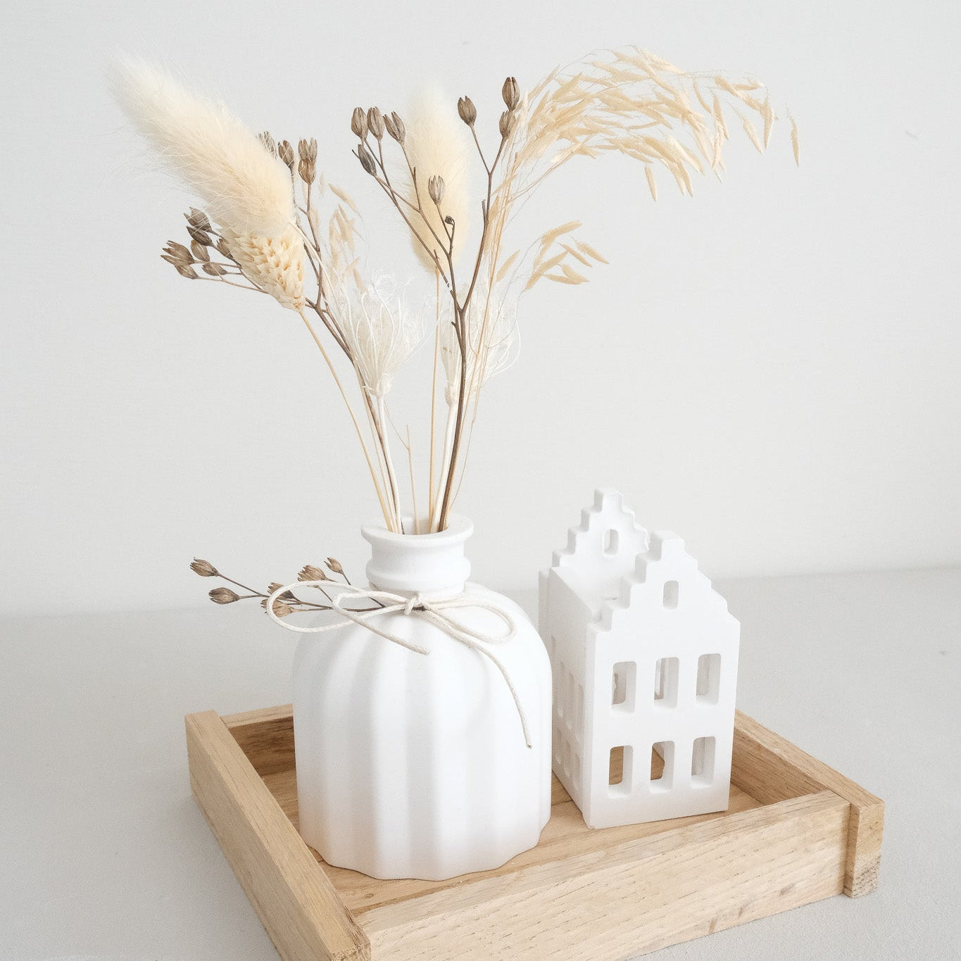 Bastelbeispiel; Grachtenhäuser als Teelicht auf Tablett mit Vase und Trockenblumen.