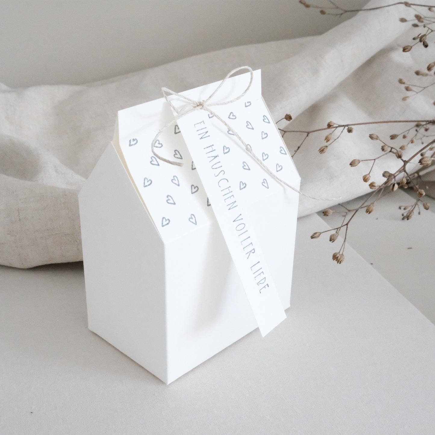 Anwendungsbeispiel für den Hintergrundstempel mit Herzen. Haus aus Papier und mit Herzen bestempelt.