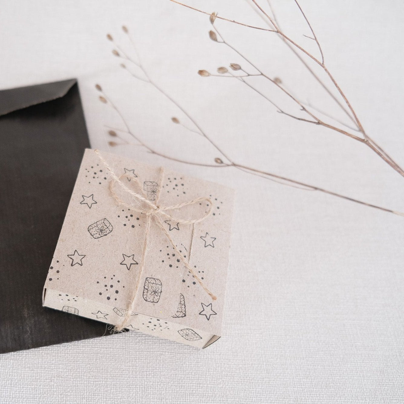 Bastelbeispiel; Geschenkbox aus Kraftpapier, bestempelt mit Sternen und Punkten sowie Geschenken.