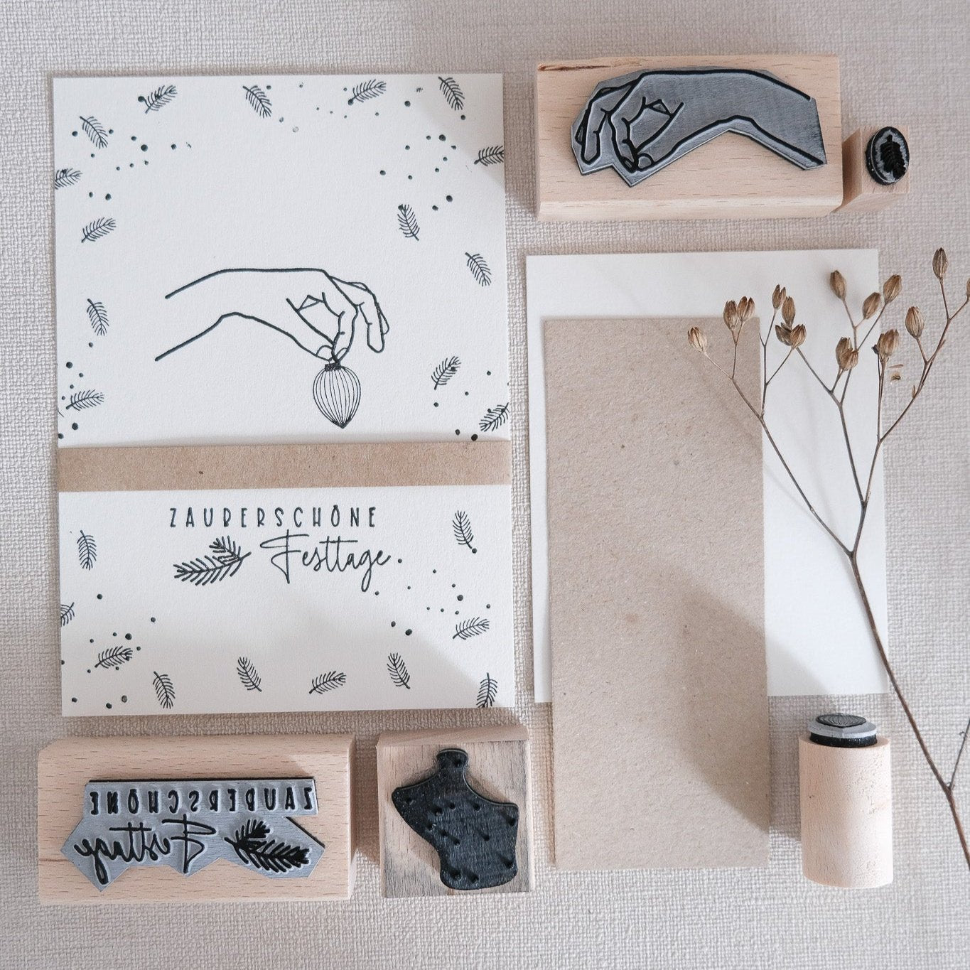 Bastelbeispiel; Weihnachtskarte mit Hand und Weihnachtskugeln zwischen den Fingern.