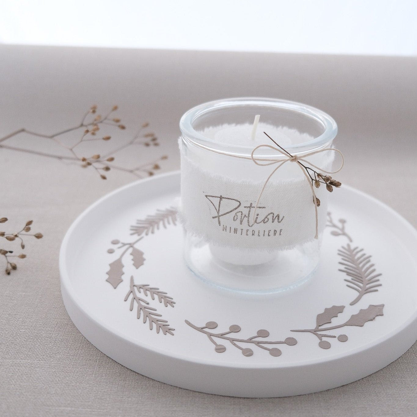 Anwendungsbeispiel von runder Schablone mit diversen Winterzweigen. Teller mit Kerzenglas und Motiv mit Strukturpaste auf Teller gestrichen.