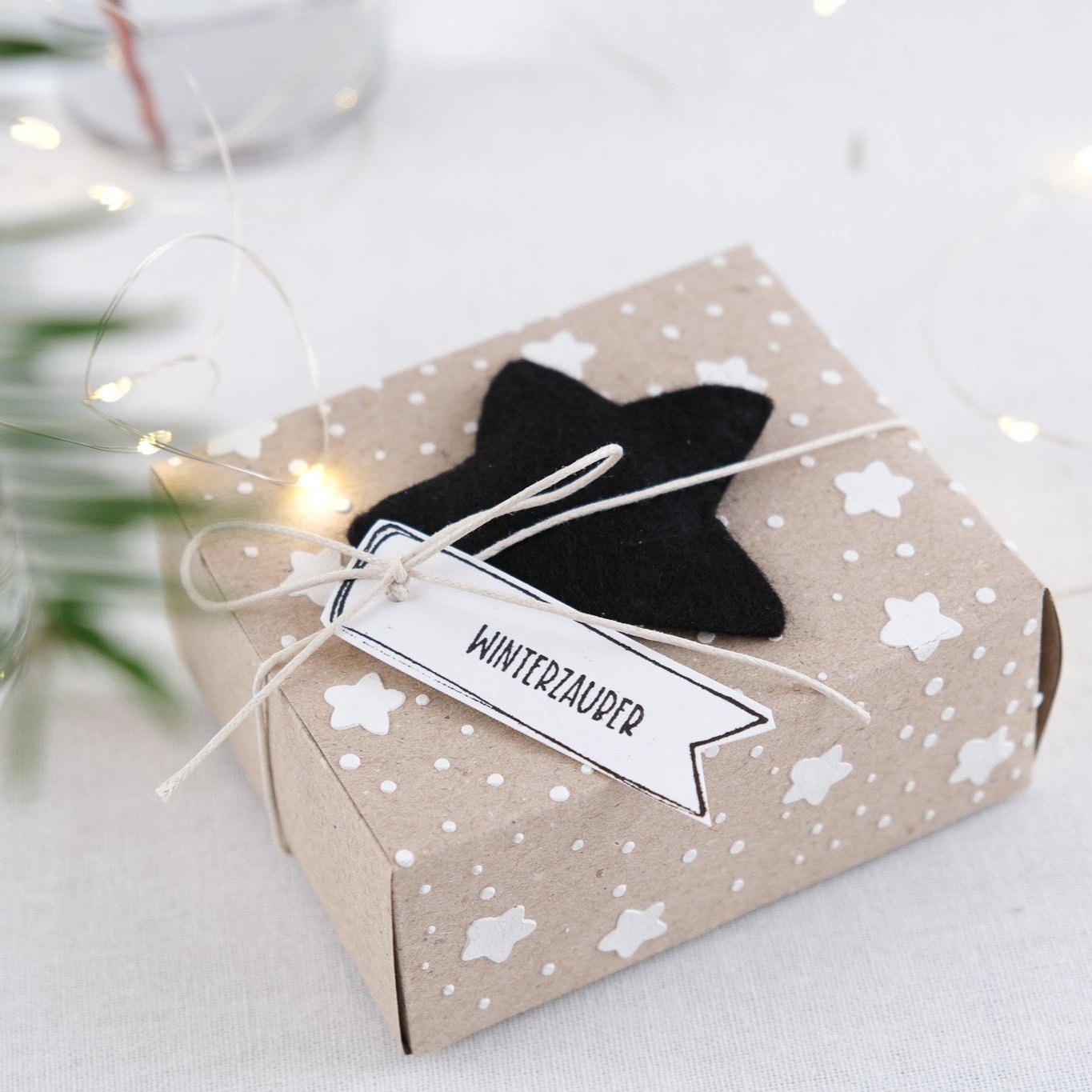 Anwendungsbeispiel Schablone mit Sternen und Punkten auf einer Geschenkbox aus Kraftpapier.