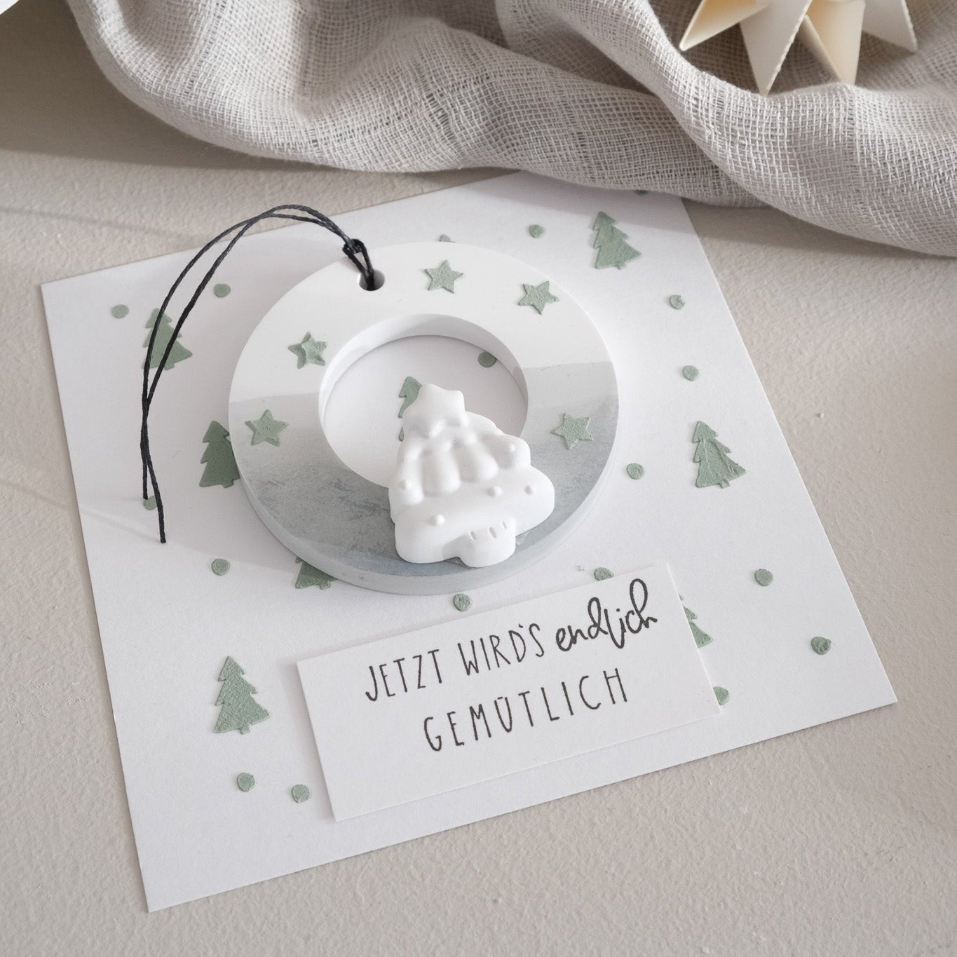 Anwenungsbeispiel für den Stempel "Jetzt wird`s endlich gemütlich". Weihnachtliche Karte mit Anhänger aus gegossenen Material.
