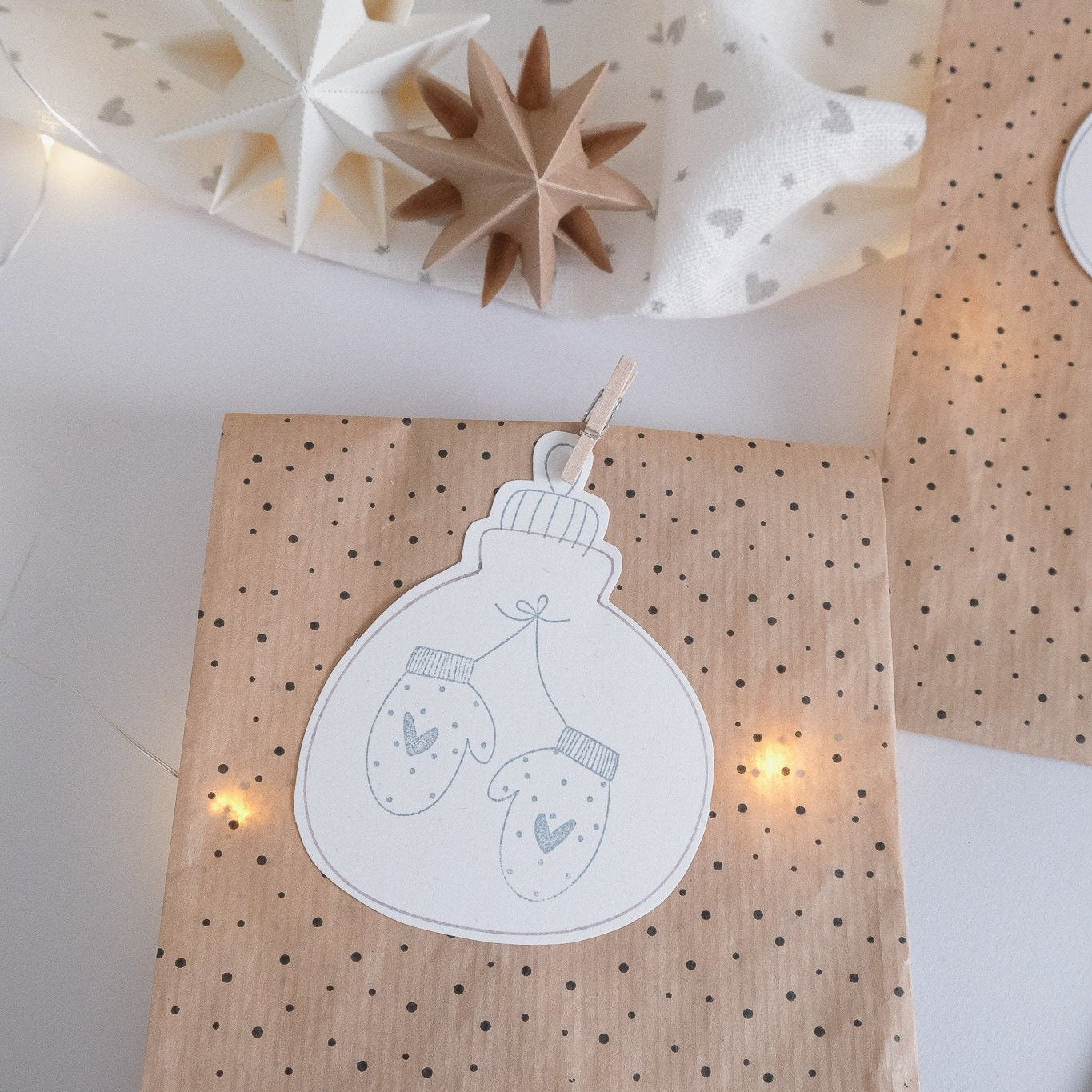 Anwendungsbeispiel für den Stempel mit Weihnachtskugel Anhänger. Geschenktüte mit Anhänger in Weihnachtskugel Form. Darin Handschuhe als Motiv.