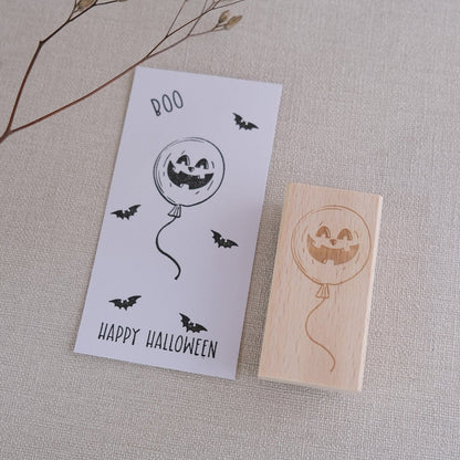 Holzstempel 3 x 6 cm Ballon mit Halloweengesicht.