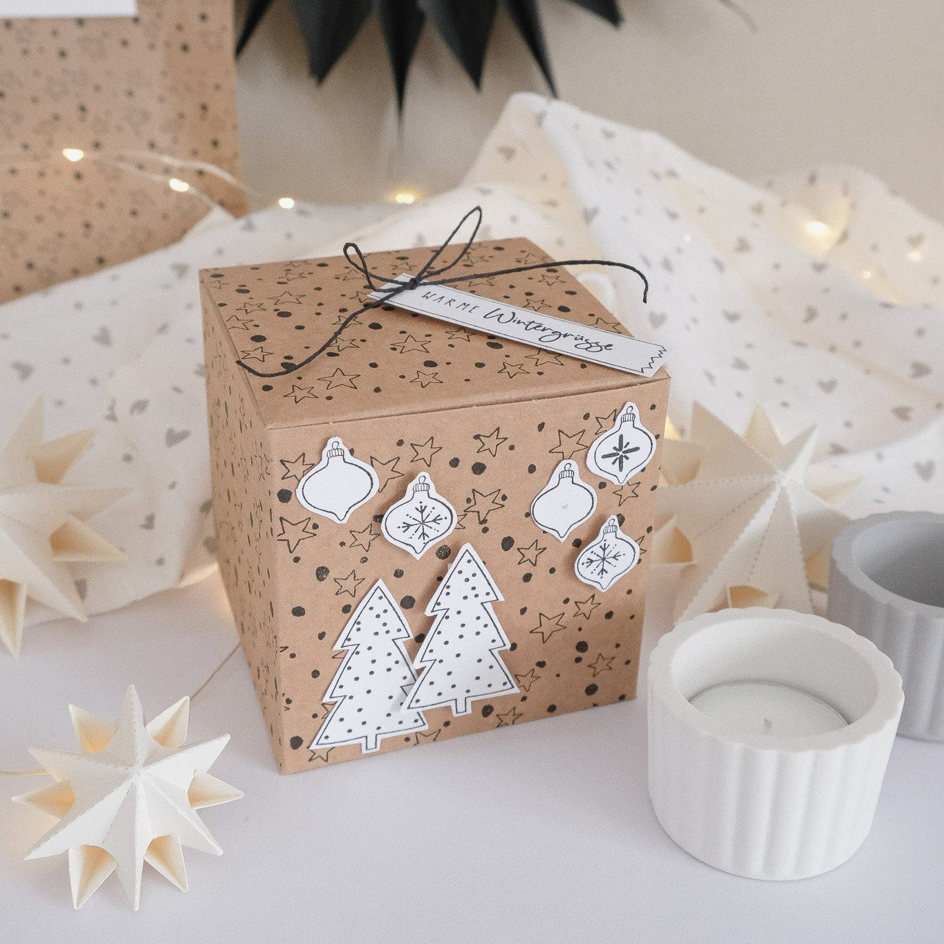 Bastelbeispiel zum Stempel "Punkte und Sterne". Kraftpapierbox mit dem Stempel komplett bestempelt. Tannenmotive und Kugelmotive wurden mit weissen Papier aufgeklebt.