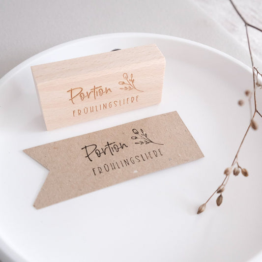 Holzstempel 3 x 6 cm. Text "Portion Frühlingsliebe" mit Zweig.